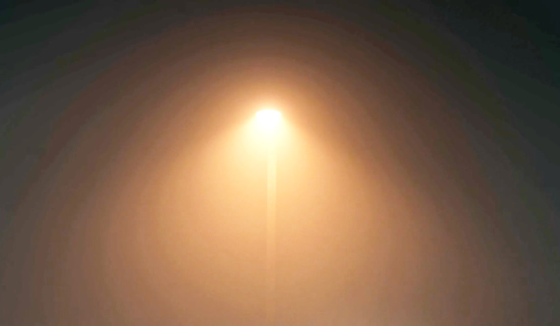 Before and after: a foggy night scene with a street lamp, shadows lifted. Left: visible banding rings around the lamp. Right: the same frame after Deband, a smooth glow.